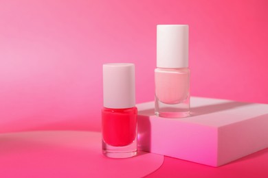 Photo of Nail polish in bottles on pink background