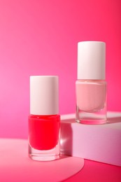 Photo of Nail polish in bottles on pink background