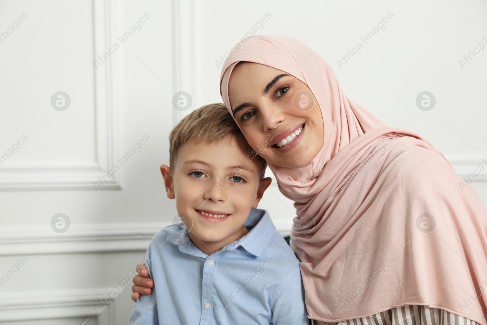 Photo of Muslim woman and her son spending time together at home