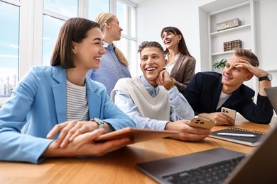 Photo of Group of people using different gadgets at wooden table in office. Modern technology