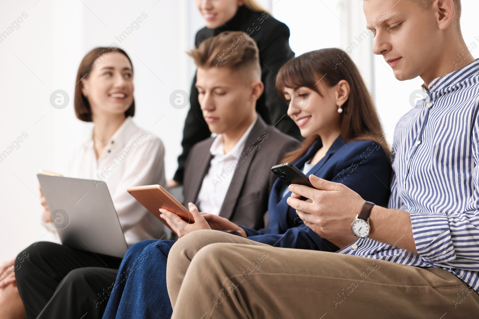 Photo of Group of people using different gadgets indoors, selective focus. Modern technology