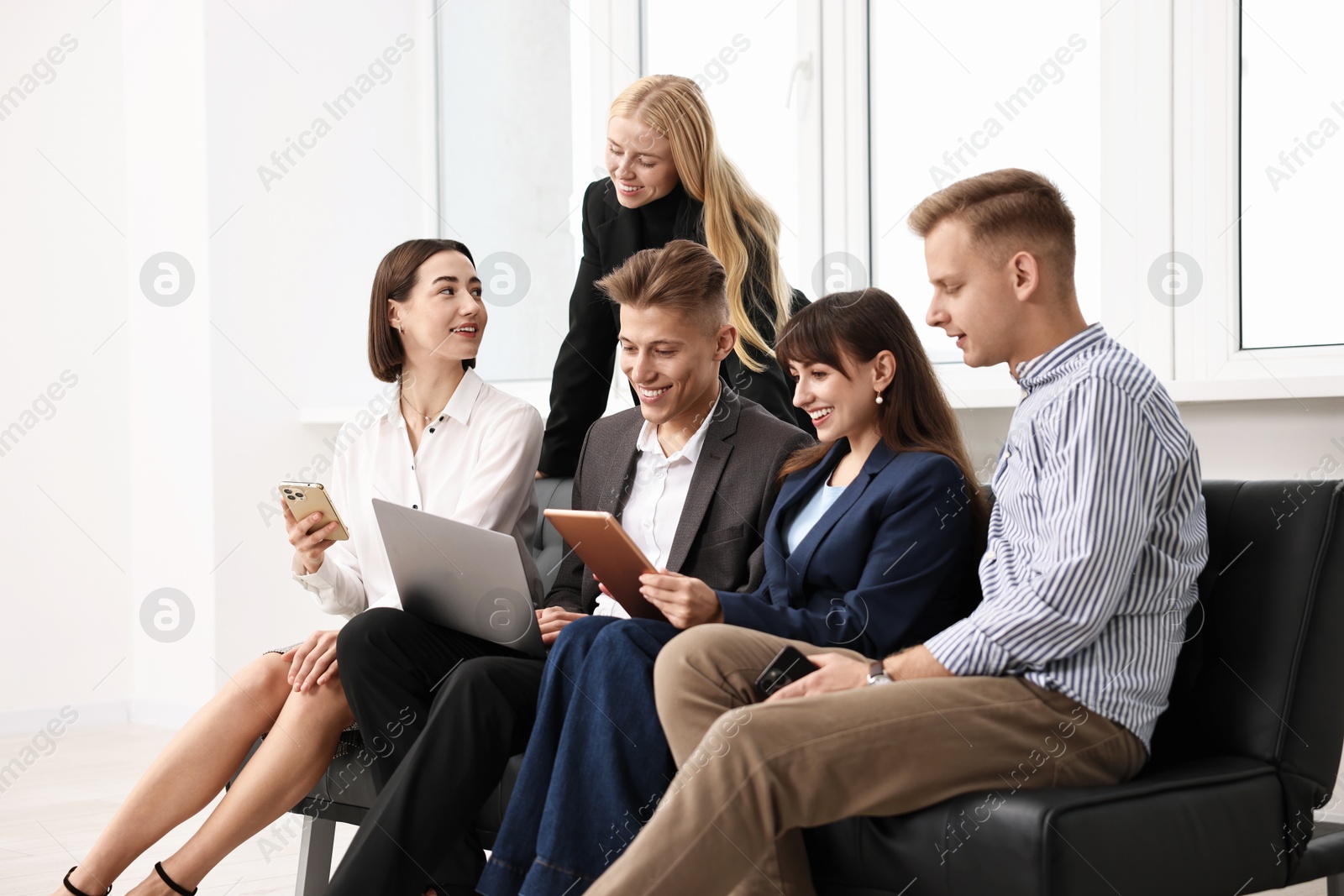 Photo of Group of people using different gadgets near window indoors. Modern technology