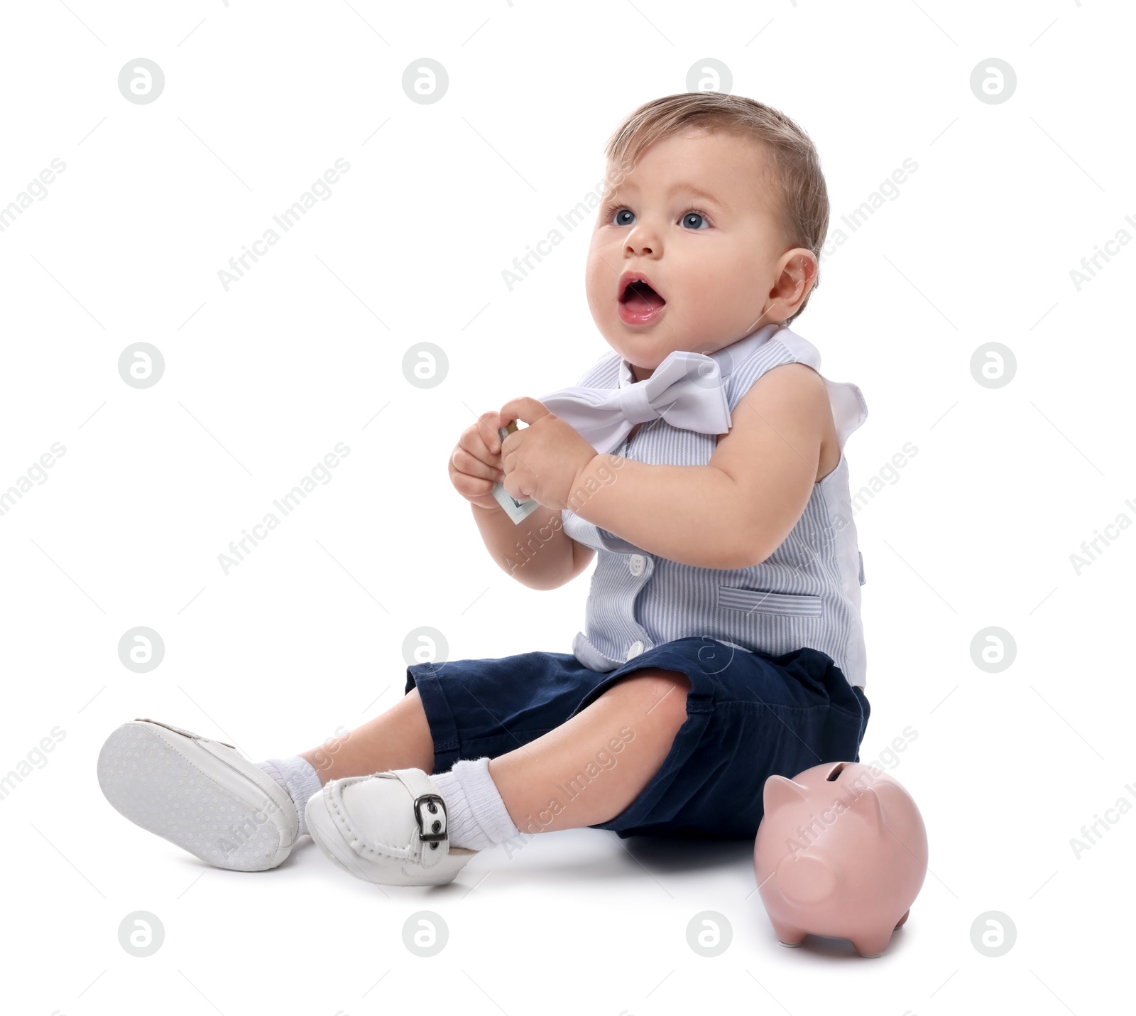 Photo of Little baby with money and piggybank on white background