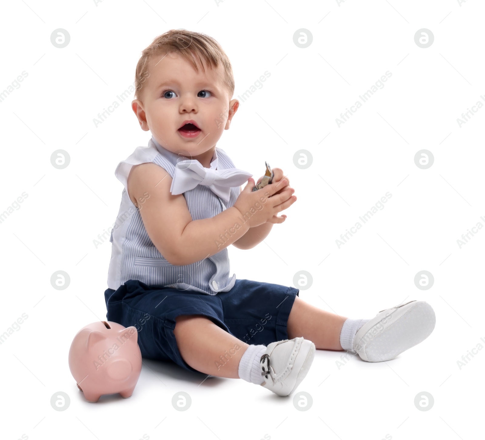 Photo of Little baby with money and piggybank on white background