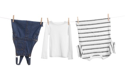 Different clothes drying on laundry line against white background