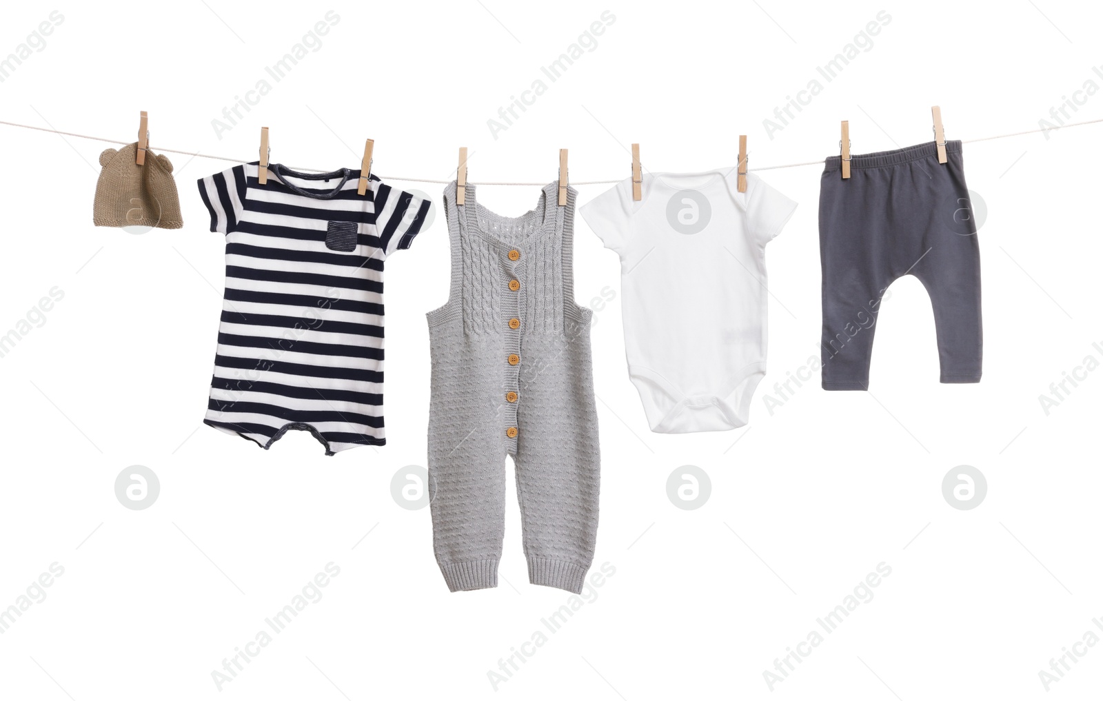 Photo of Different baby clothes drying on laundry line against white background