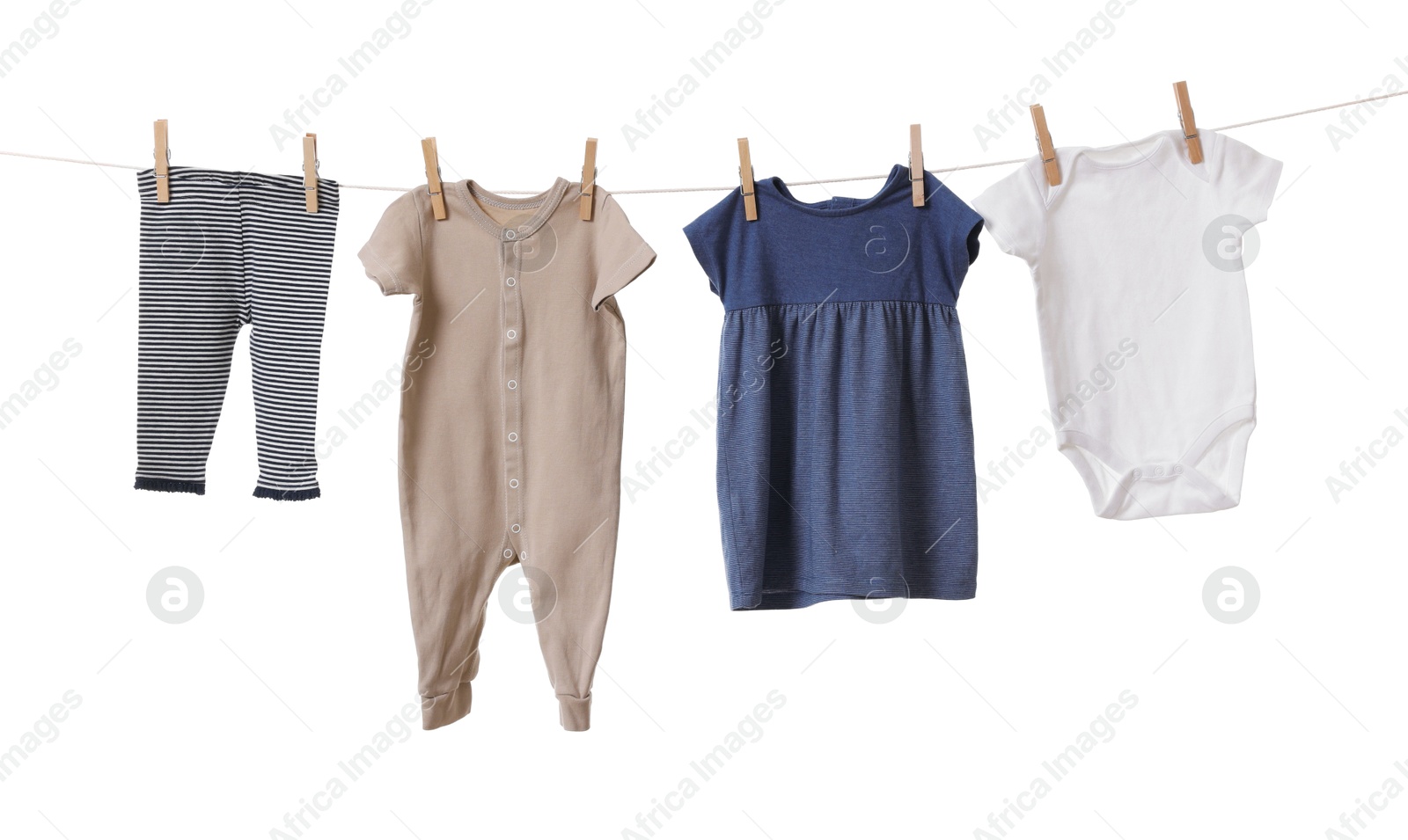 Photo of Different baby clothes drying on laundry line against white background