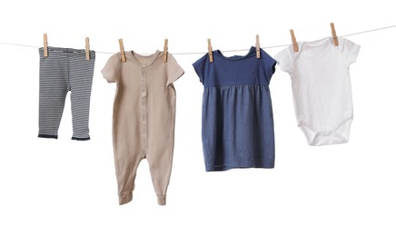 Photo of Different baby clothes drying on laundry line against white background