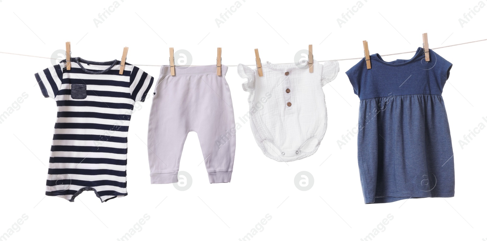 Photo of Different baby clothes drying on laundry line against white background