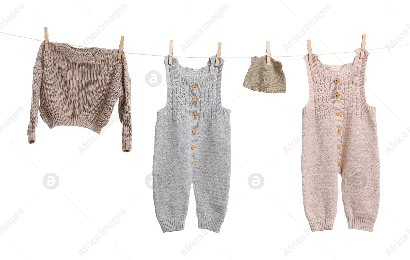 Photo of Different baby clothes drying on laundry line against white background