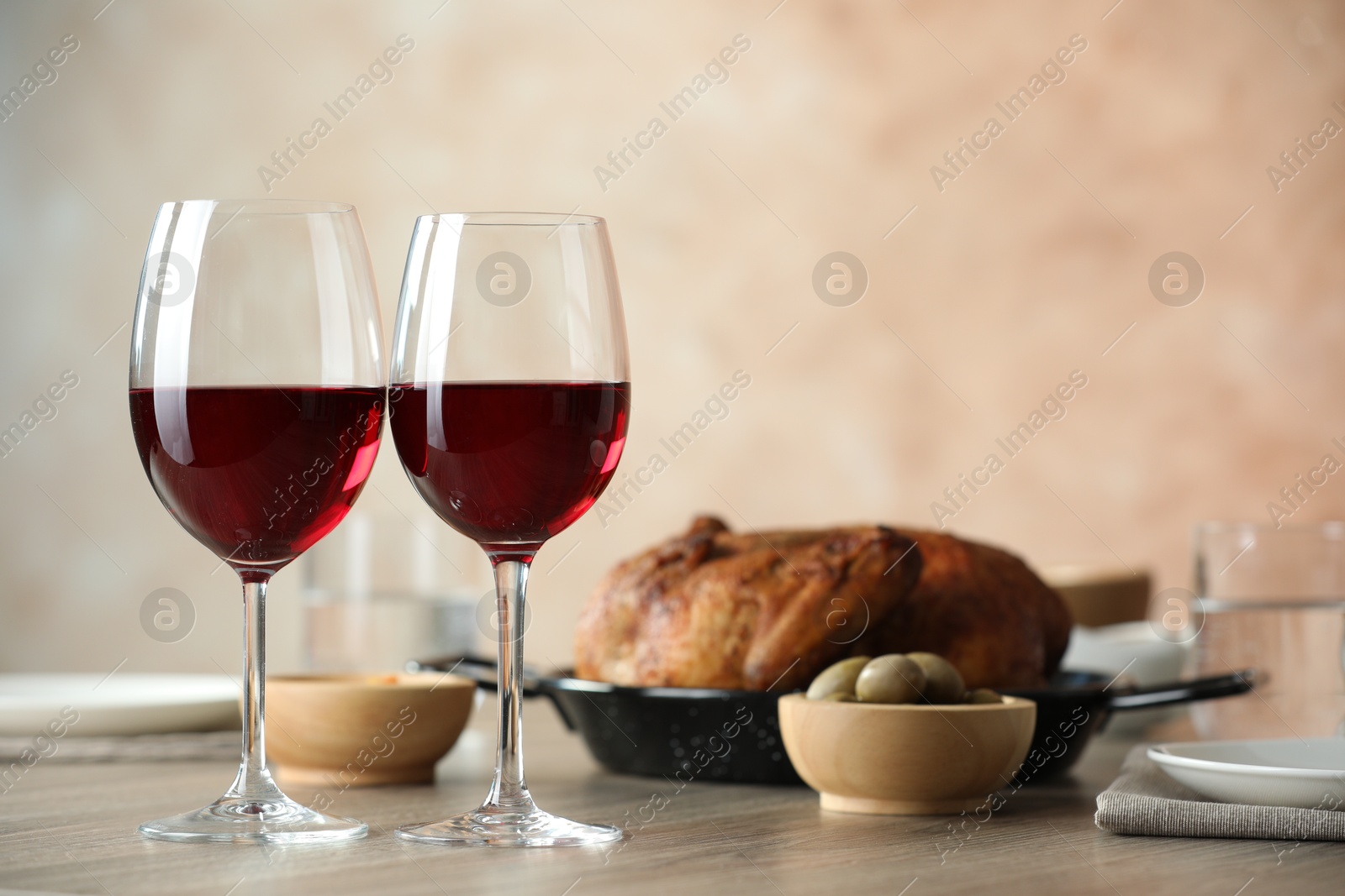 Photo of Red wine and delicious dinner served on wooden table