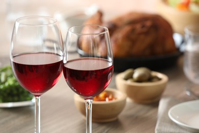 Photo of Red wine and delicious dinner served on table, closeup. Space for text