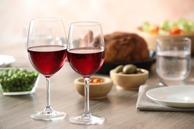 Photo of Red wine and delicious dinner served on wooden table