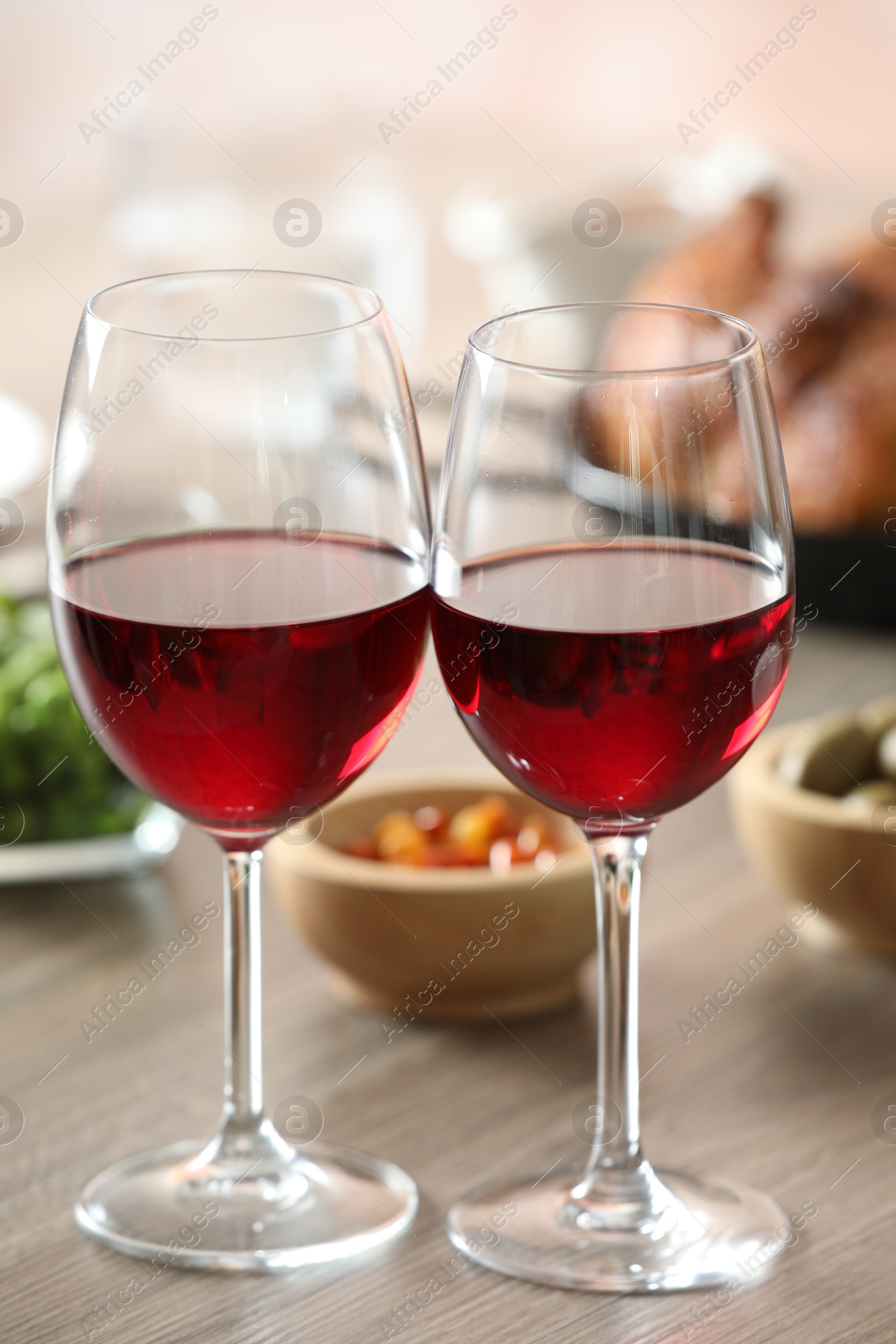 Photo of Red wine and delicious dinner served on wooden table, closeup