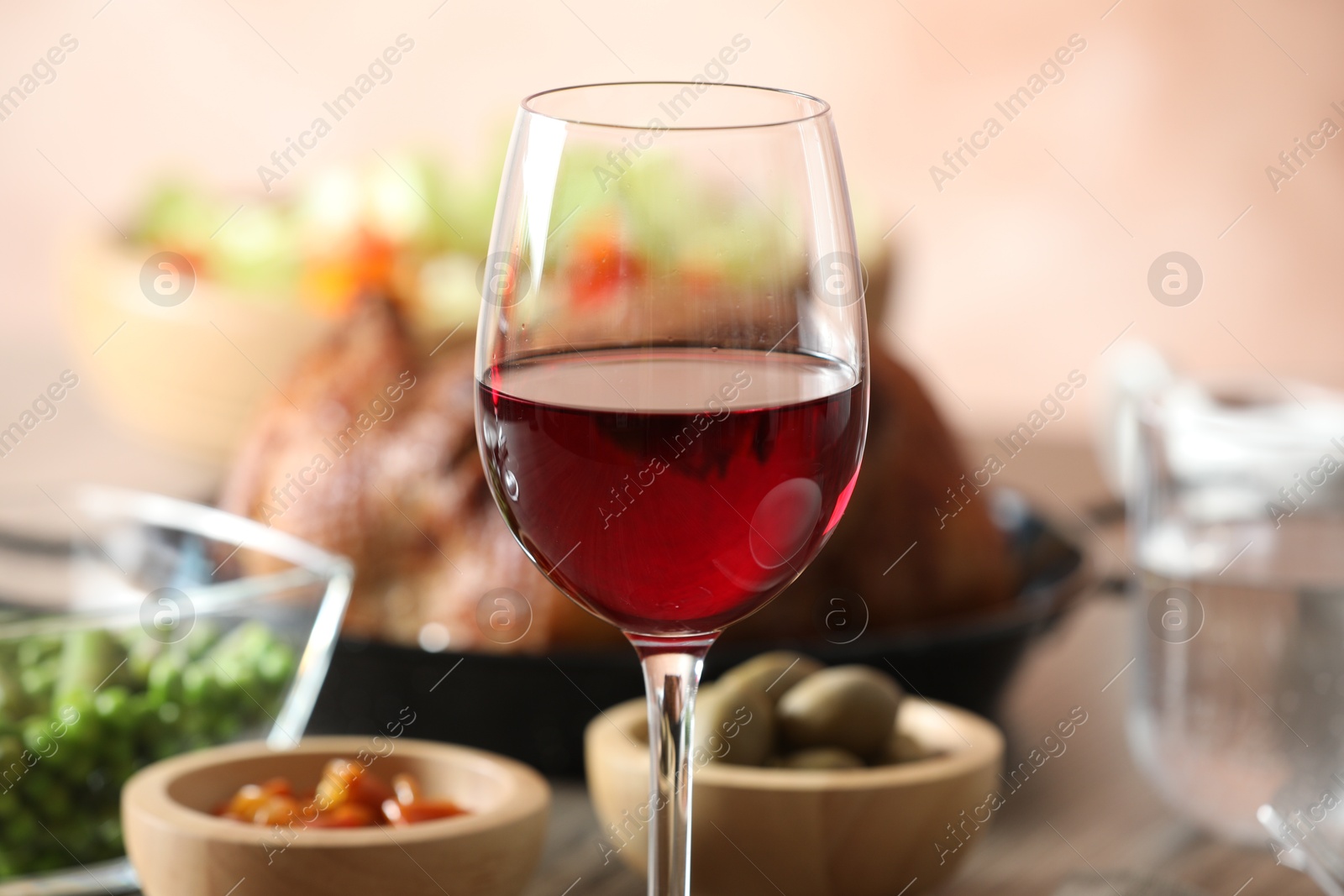 Photo of Red wine and delicious dinner served on table, closeup