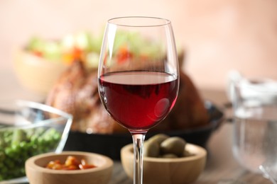 Photo of Red wine and delicious dinner served on table, closeup