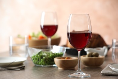 Photo of Red wine and delicious dinner served on wooden table