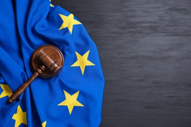 Photo of Judge's gavel and flag of European Union on grey wooden table, top view. Space for text