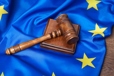 Photo of Judge's gavel and flag of European Union on wooden table