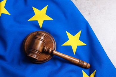 Photo of Judge's gavel and flag of European Union on grey table, top view