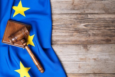 Photo of Judge's gavel and flag of European Union on wooden table, top view. Space for text