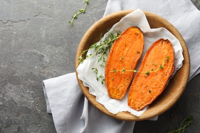 Tasty cooked sweet potato with thyme on grey table, top view