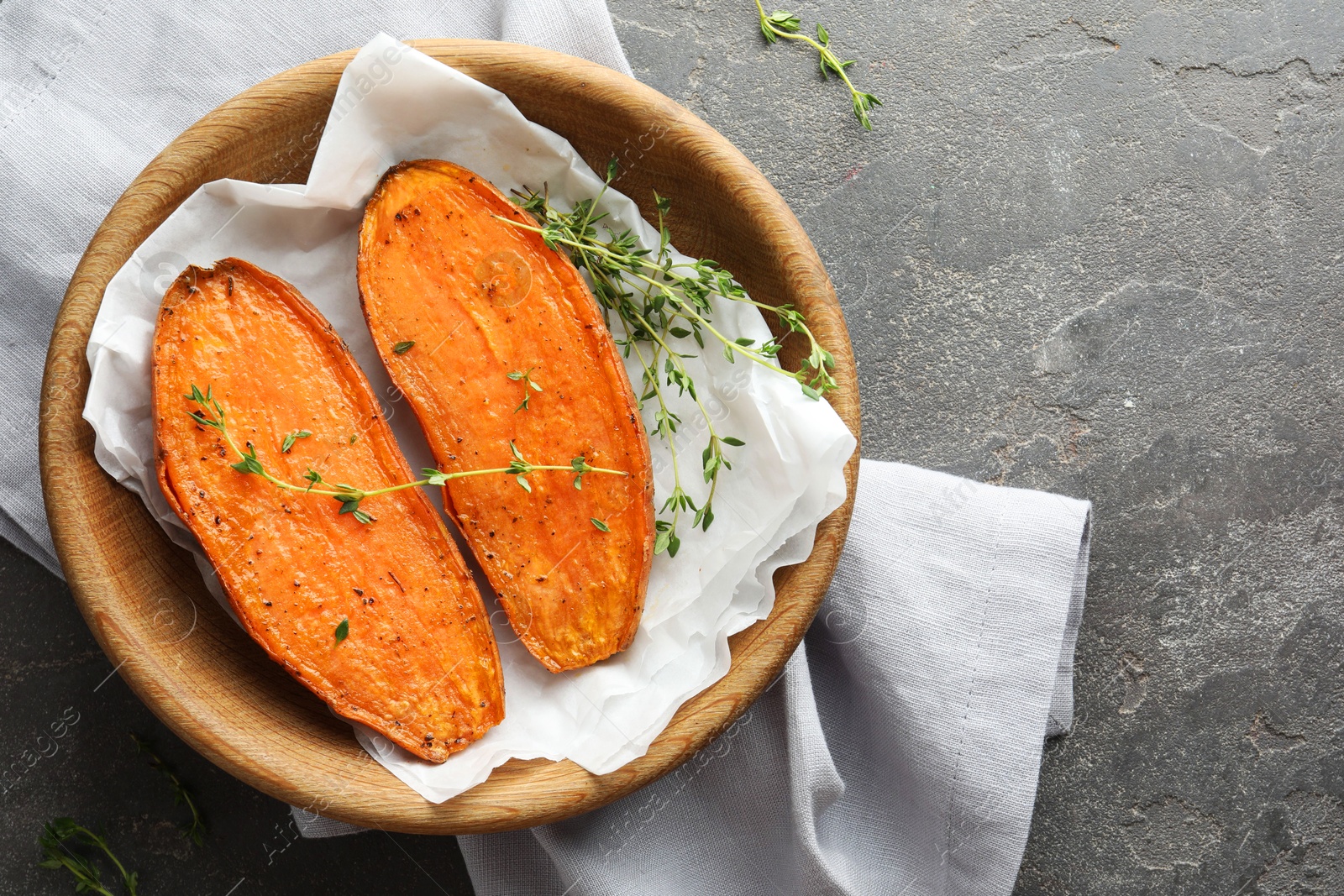 Photo of Tasty cooked sweet potato with thyme on grey table, top view