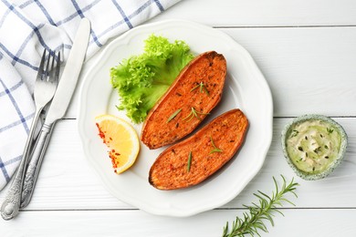 Photo of Tasty baked sweet potato served on white wooden table, flat lay