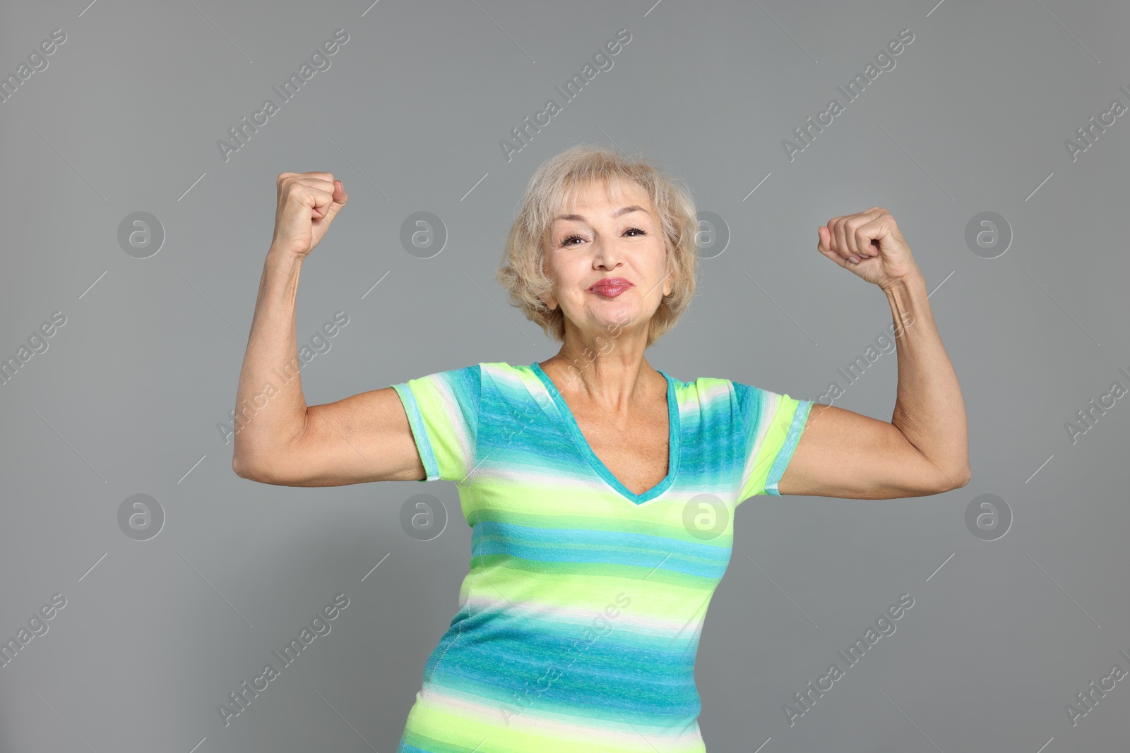 Photo of Senior woman exercising on light grey background