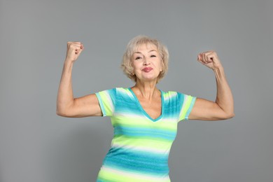 Photo of Senior woman exercising on light grey background