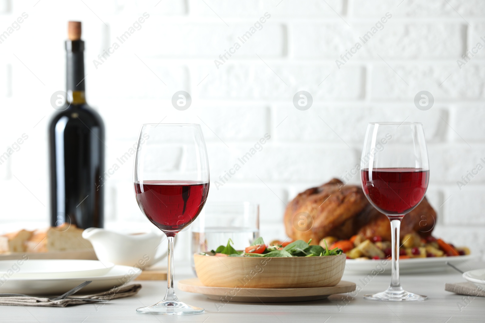 Photo of Red wine and delicious dinner served on light table