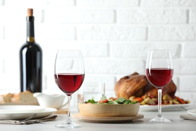 Photo of Red wine and delicious dinner served on light table