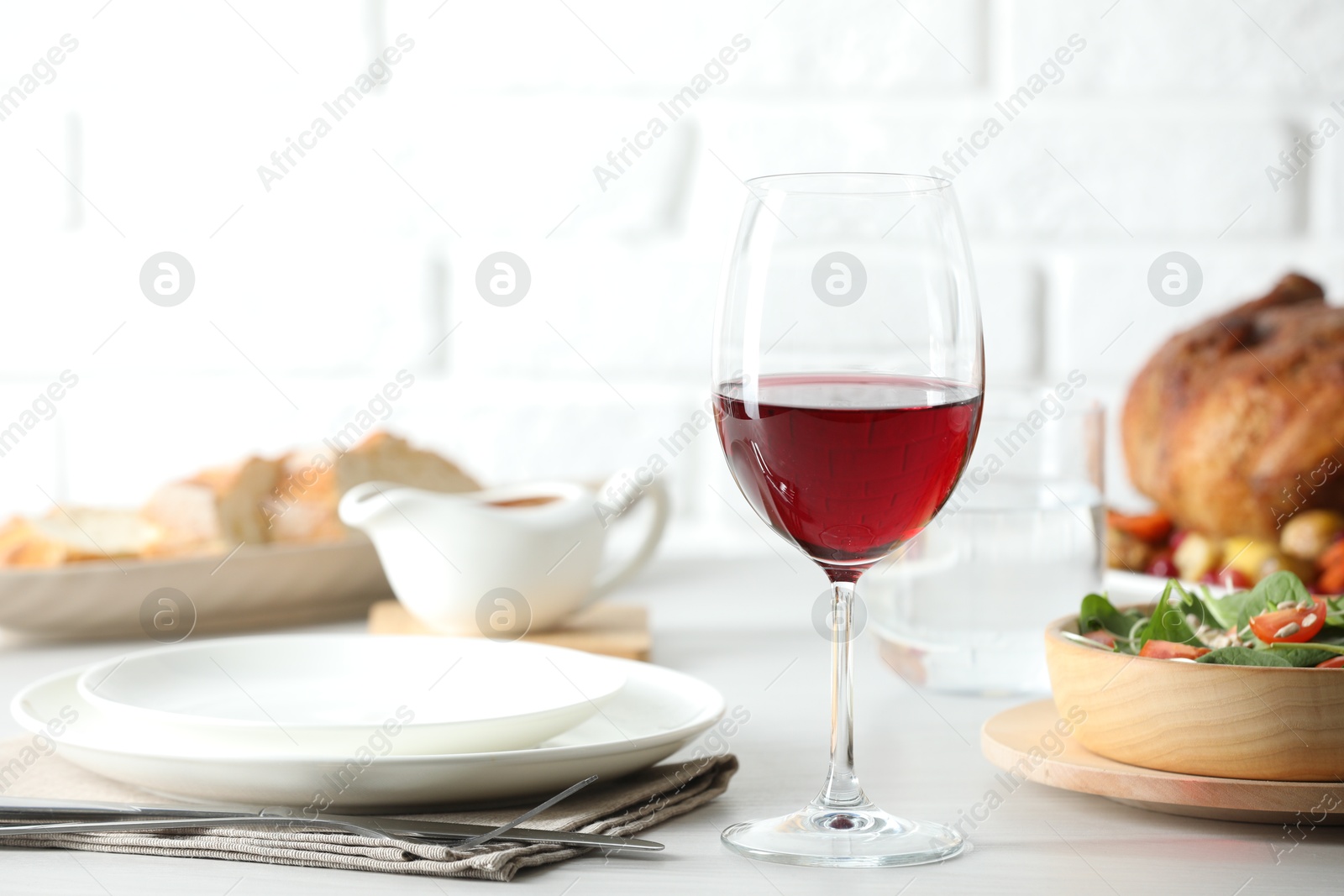 Photo of Red wine and delicious dinner served on light table