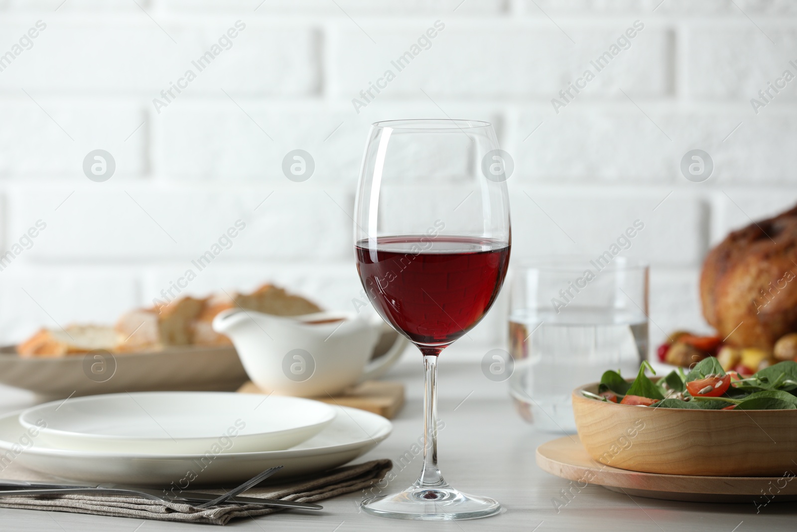 Photo of Red wine and delicious dinner served on light table