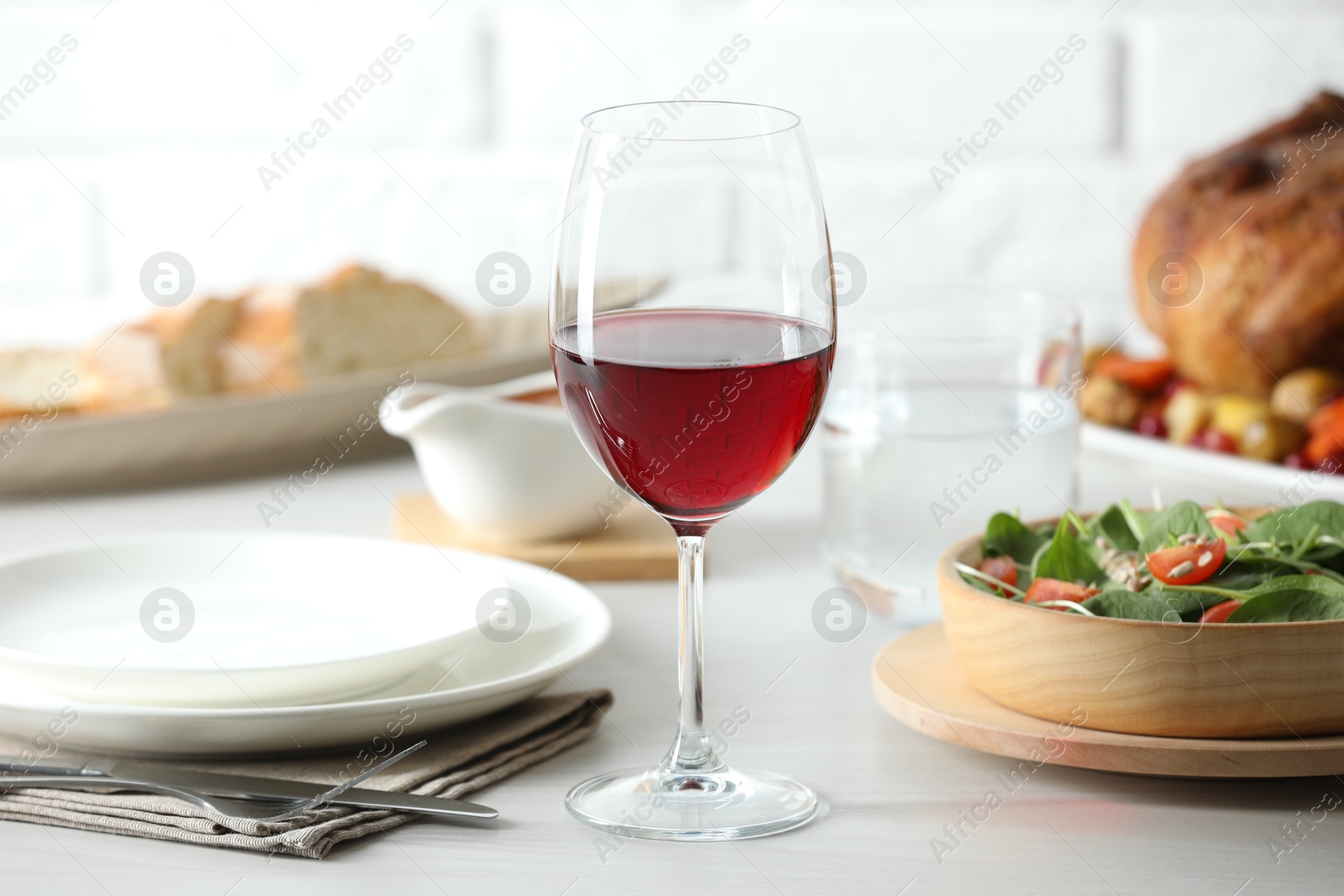 Photo of Red wine and delicious dinner served on light table