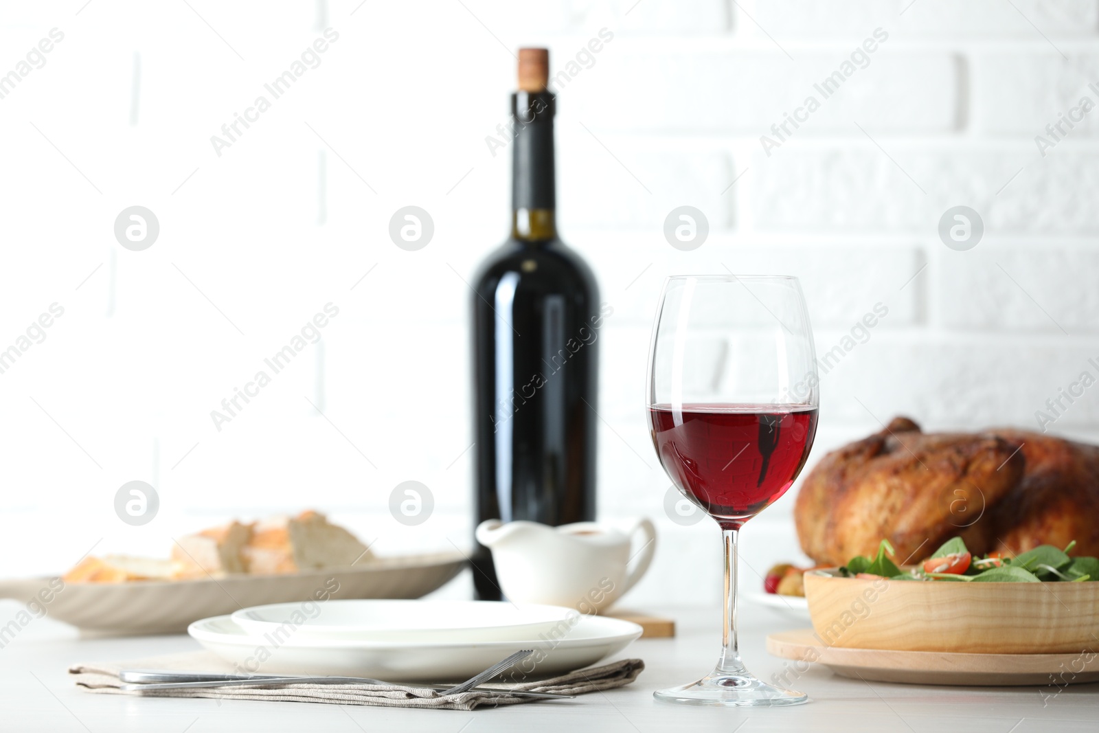 Photo of Red wine and delicious dinner served on light table