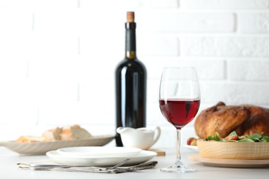 Photo of Red wine and delicious dinner served on light table