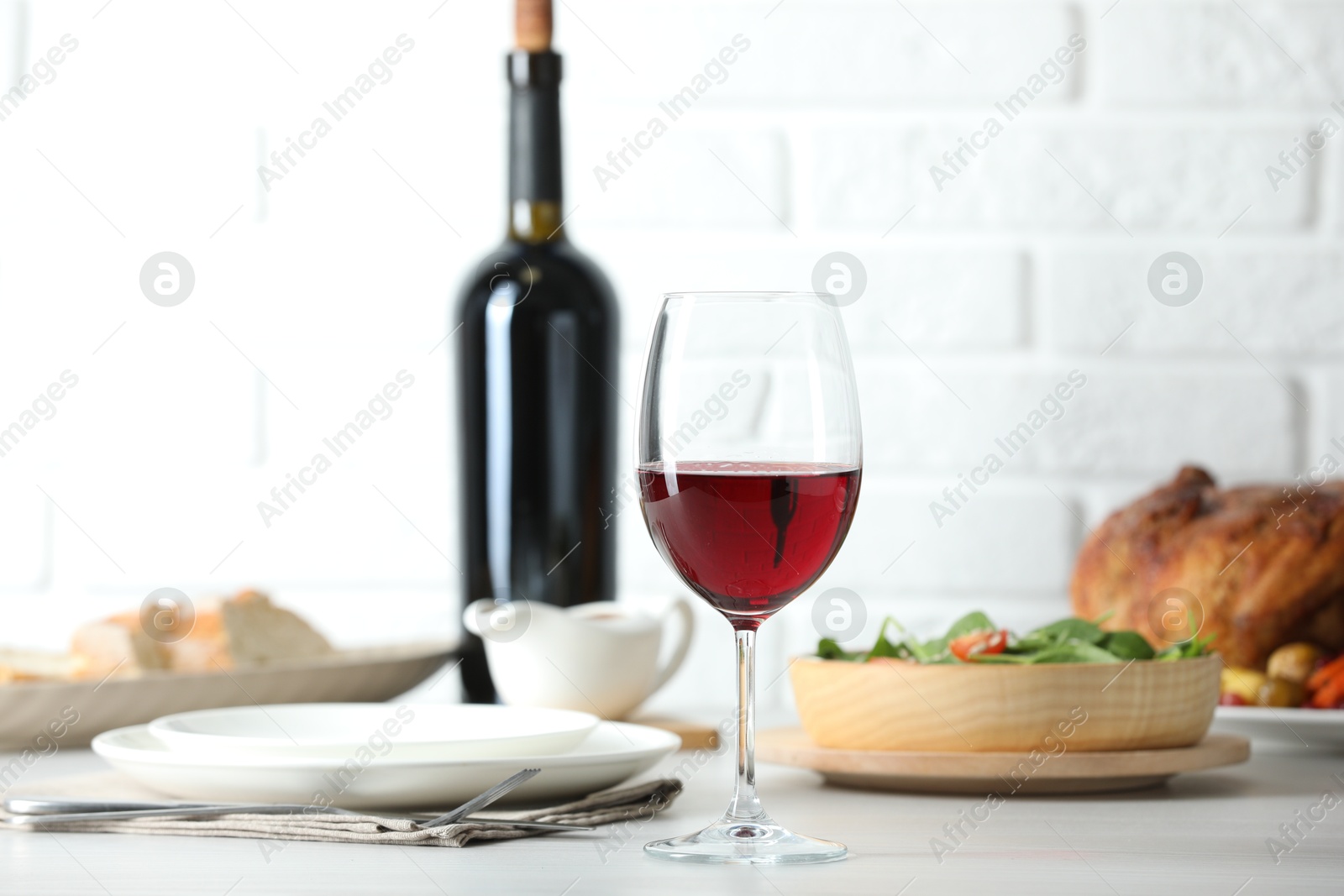 Photo of Red wine and delicious dinner served on light table