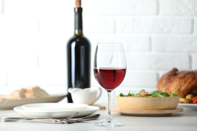 Photo of Red wine and delicious dinner served on light table