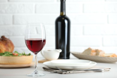 Photo of Red wine and delicious dinner served on light table