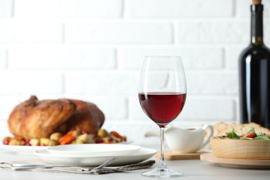 Photo of Red wine and delicious dinner served on light table