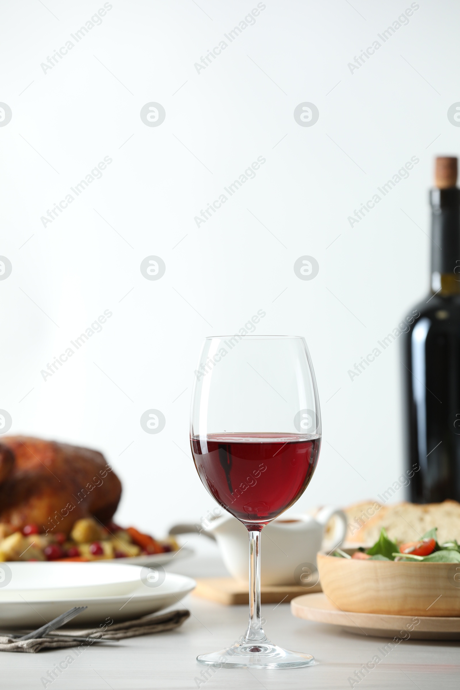 Photo of Red wine and delicious dinner served on light table