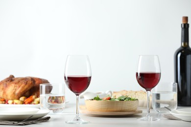 Photo of Red wine and delicious dinner served on light table