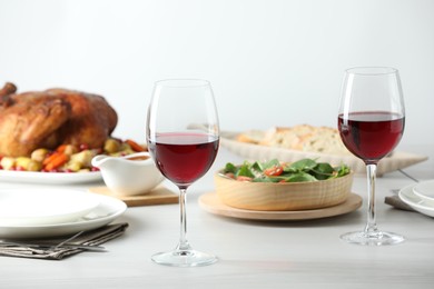 Photo of Red wine and delicious dinner served on light table