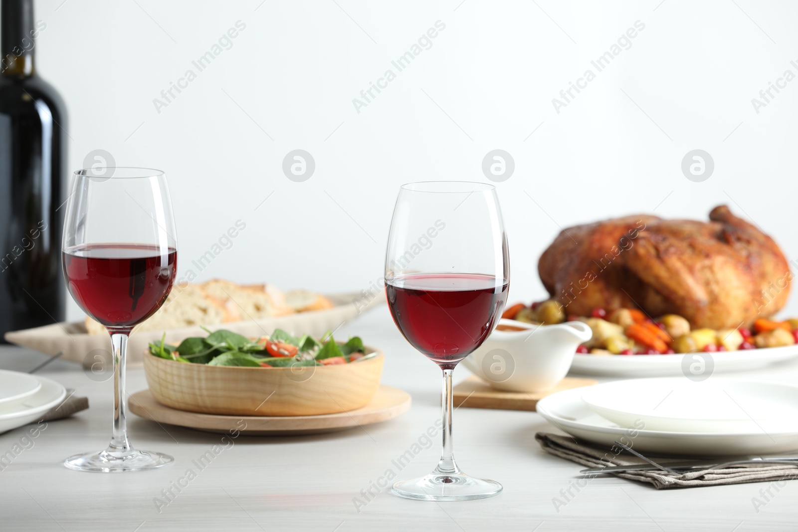 Photo of Red wine and delicious dinner served on light table