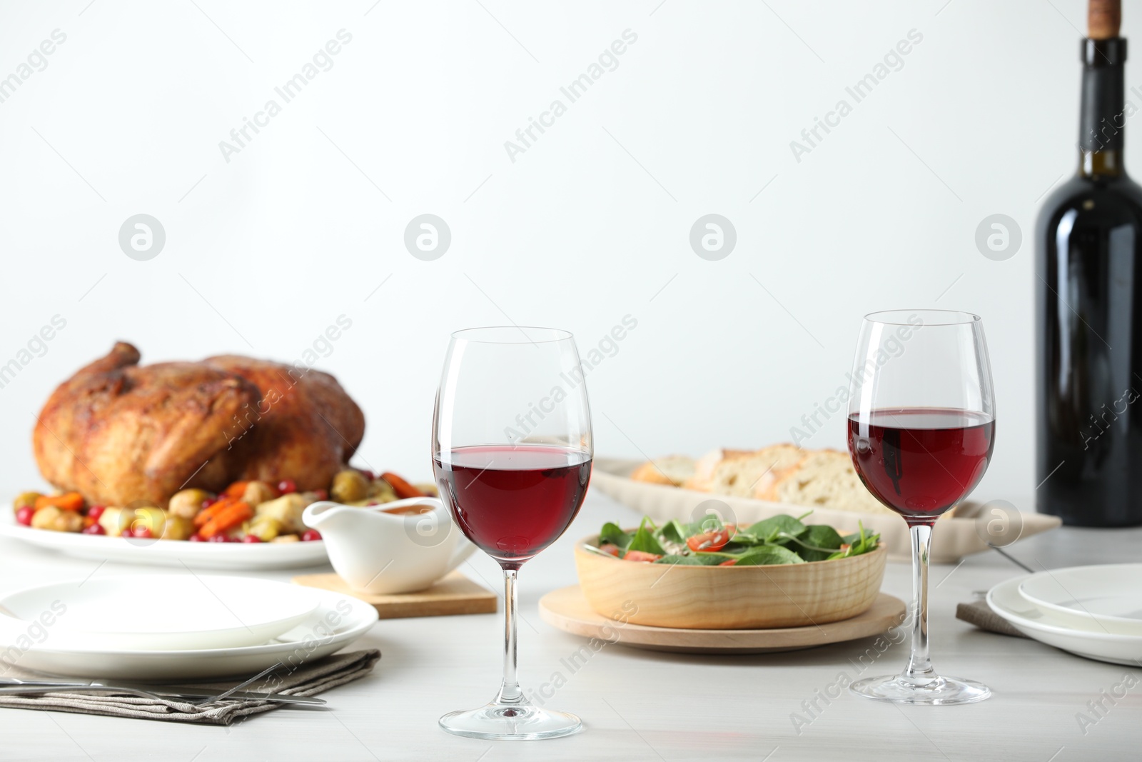 Photo of Red wine and delicious dinner served on light table