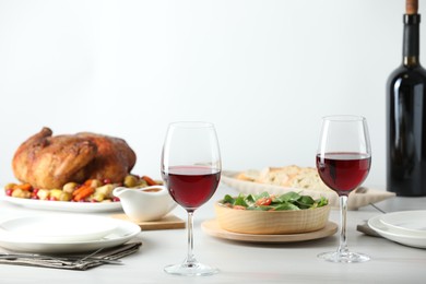 Photo of Red wine and delicious dinner served on light table