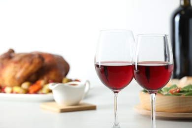 Photo of Red wine and delicious dinner served on light table