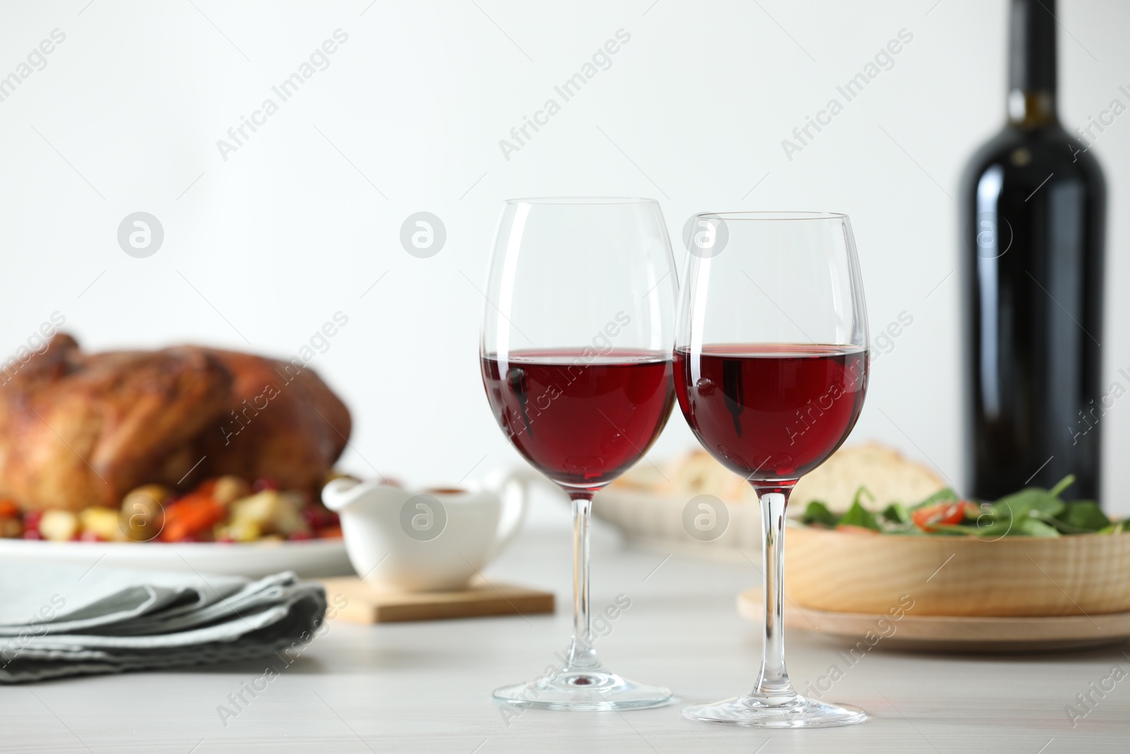 Photo of Red wine and delicious dinner served on light table