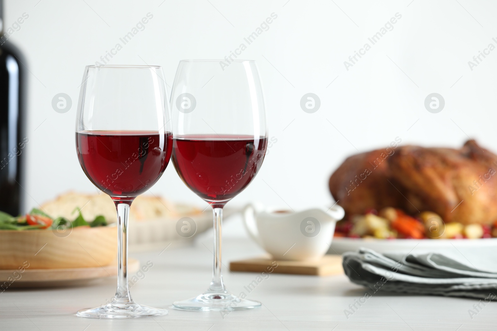 Photo of Red wine and delicious dinner served on light table